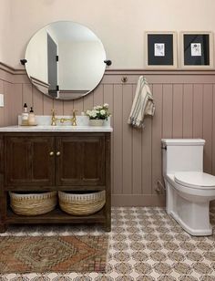 a bathroom with a toilet, sink and mirror in it's centerpieces