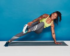 a woman is doing an exercise on a yoga mat with her leg up and one hand in the air