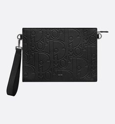 The pouch is a House staple. Displaying the virtuosity of the House ateliers, the Dior Gravity leather showcases the iconic motif delicately embossed on black calfskin with a Dior signature on the front. The spacious zip compartment is ideal for a phone and features six card slots. Thanks to its removable grained calfskin wrist strap, the pouch can be carried by hand or slipped into a bag.. Designer Black Leather Pouch, Luxury Textured Leather Pouch For Daily Use, Dior Pouch, Triangle Pouch, Dior Atelier, Dior Star, Dior Men, Icon Shoes, Dior Book Tote