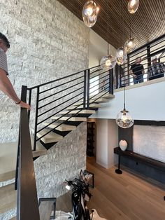 a man standing on top of a stair case next to a bike in a living room