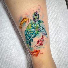 a woman's leg with a turtle and fish tattoo on it