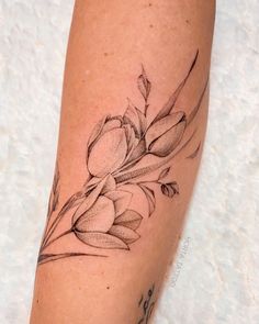 a woman's leg with a flower tattoo on it