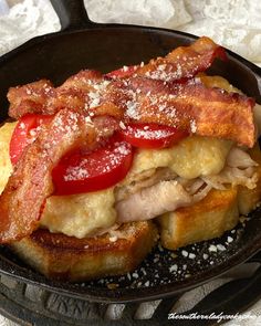 a sandwich with meat, tomatoes and cheese in a frying pan