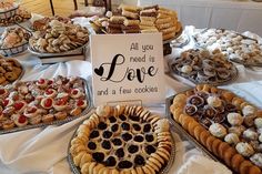 a table topped with lots of different types of cookies and pastries on trays