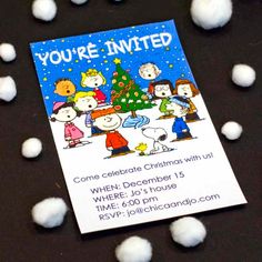 a christmas card with peanuts around it on a black surface surrounded by white snowballs