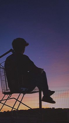 a person sitting in a chair watching the sunset