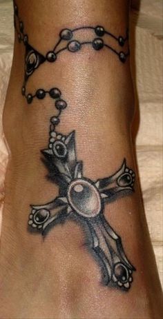 a foot with a cross tattoo on it