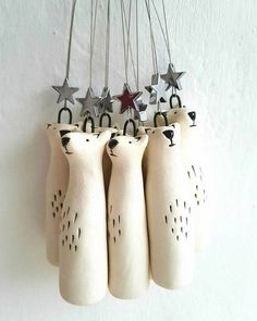 five white ceramic bears hanging from strings with stars on them