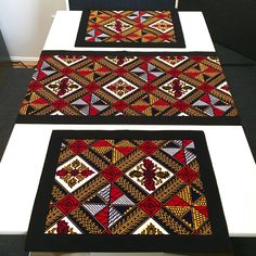 two black and red rugs sitting on top of a white table next to each other