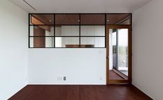 an empty room with wood flooring and white walls that have glass panels on them