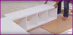 a person standing next to a white shelf on top of a wooden flooring board