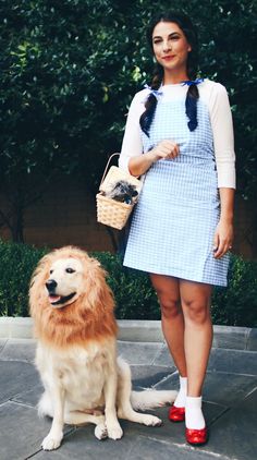 a woman standing next to a brown dog