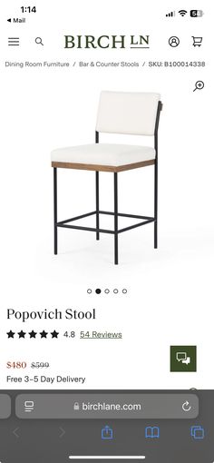 a white chair with black legs and a wooden seat on the back, in front of a