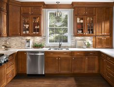 a kitchen with wooden cabinets and white counter tops, an open window above the dishwasher