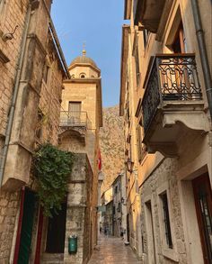 an alley way with stone buildings and balconies