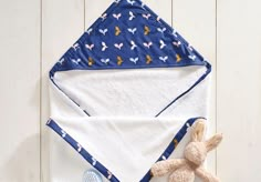 a teddy bear sitting next to a blue and white towel