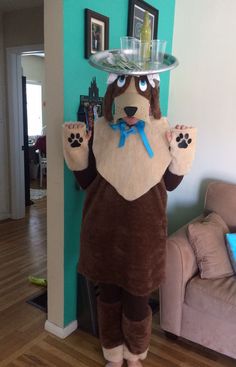 a person dressed as a dog holding a tray on his head and paw prints on it