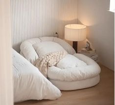 a large round bed sitting in the corner of a room next to a night stand