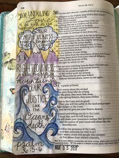 an open bible with handwritten words on the page and watercolors in it