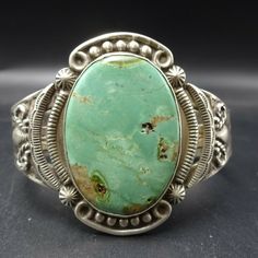 "VINTAGE NAVAJO BRACELET DESCRIPTION: This wonderful Harvey Era cuff features extensive stampwork and a huge specimen of gorgeous light green variscite. This bracelet will be a cherished addition to your collection of fine vintage Native American jewelry. MEASUREMENTS: Interior of the cuff measures 5 1/4\" with an additional 1 1/4\" slightly adjustable gap. Total circumference: 6 1/2\" Measures 2 1/2\" straight across the widest part (from wrist bone to wrist bone) Bracelet face measures 1 3/4\" Green Bohemian Bracelets With Patina, Artisan Green Cuff Bangle Bracelet, Vintage Green Bracelet With Patina, Vintage Green Adjustable Cuff Bracelet, Artisan Green Patina Bracelets, Artisan Green Bracelet With Patina, Green Artisan Bracelet With Patina, Handmade Southwestern Green Cuff Bracelet, Green Patina Cuff Bracelet Bangle