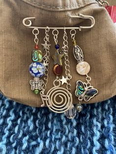 a purse with some charms hanging from it's front and back sides on a blue blanket