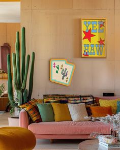 a living room filled with lots of furniture and cactus plants on the wall behind it