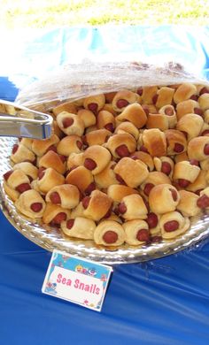 a bowl full of hot dogs on a table with a sign that says sea snailie