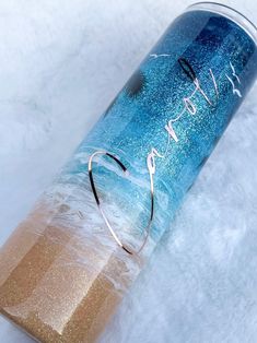 a blue and gold can with the word love written on it, sitting in snow