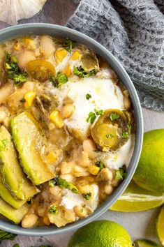 a bowl filled with beans, avocado and other vegetables next to limes