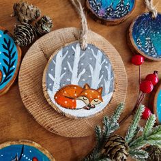 some ornaments that are on top of a wooden table with pine cones and other decorations