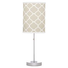 a lamp with a white and grey shade on the base, it is lit up