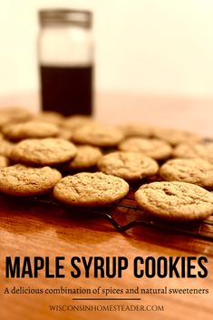 a wooden table topped with cookies and a glass of syrup