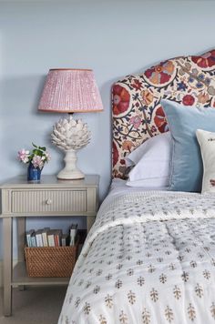 a bedroom with blue walls and a floral headboard