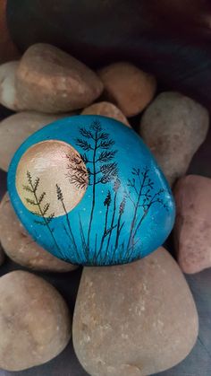 a painted rock sitting on top of some rocks