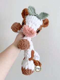 a crocheted giraffe stuffed animal being held by someone's hand