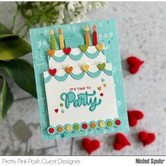 a handmade birthday card with candles on it and some red flowers in the background