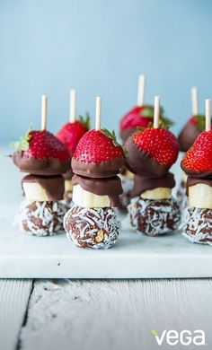 chocolate covered strawberries and bananas are arranged on sticks