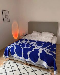 a bed with a blue and white blanket on it