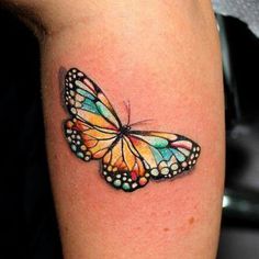 a colorful butterfly tattoo on the leg