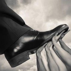 black and white photograph of two people's feet with their hands on each other