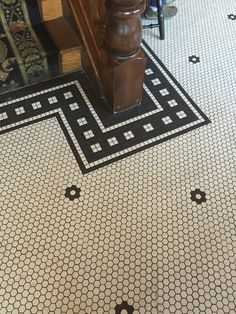 a black and white tile floor with an ornate design on the bottom half of it