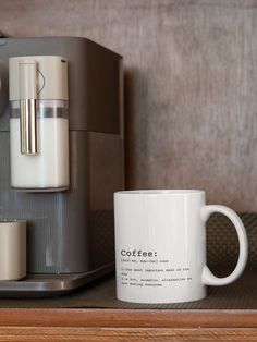 a coffee mug sitting on top of a wooden shelf next to a coffee maker and grinder