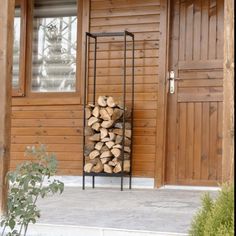 Tall black metal firewood rack holding chopped logs Indoor Firewood Rack, Storage Fireplace, Firewood Racks, Firewood Holder, Wood Holder, Room Fireplace, Firewood Rack, Log Holder, Firewood Storage