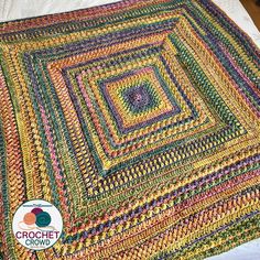 a multicolored crocheted blanket on top of a bed