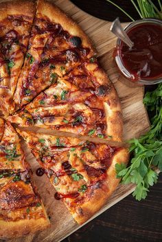 a pizza cut into eight slices on top of a wooden cutting board with sauce and parsley