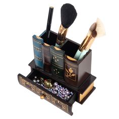 an assortment of cosmetics and makeup brushes in a wooden holder