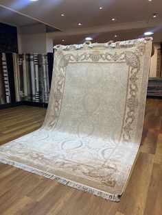 an antique rug is on display in the middle of a room with wooden flooring