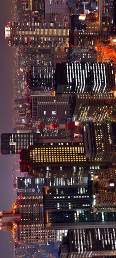 an aerial view of skyscrapers at night in new york city, with the empire building lit up