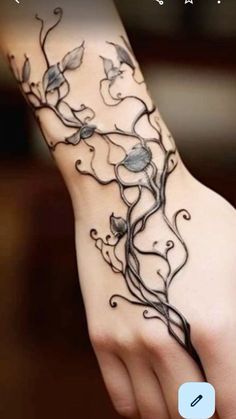 a woman's arm with flowers and vines on it, in the middle of her hand