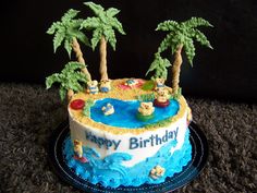 a blue and white birthday cake with palm trees